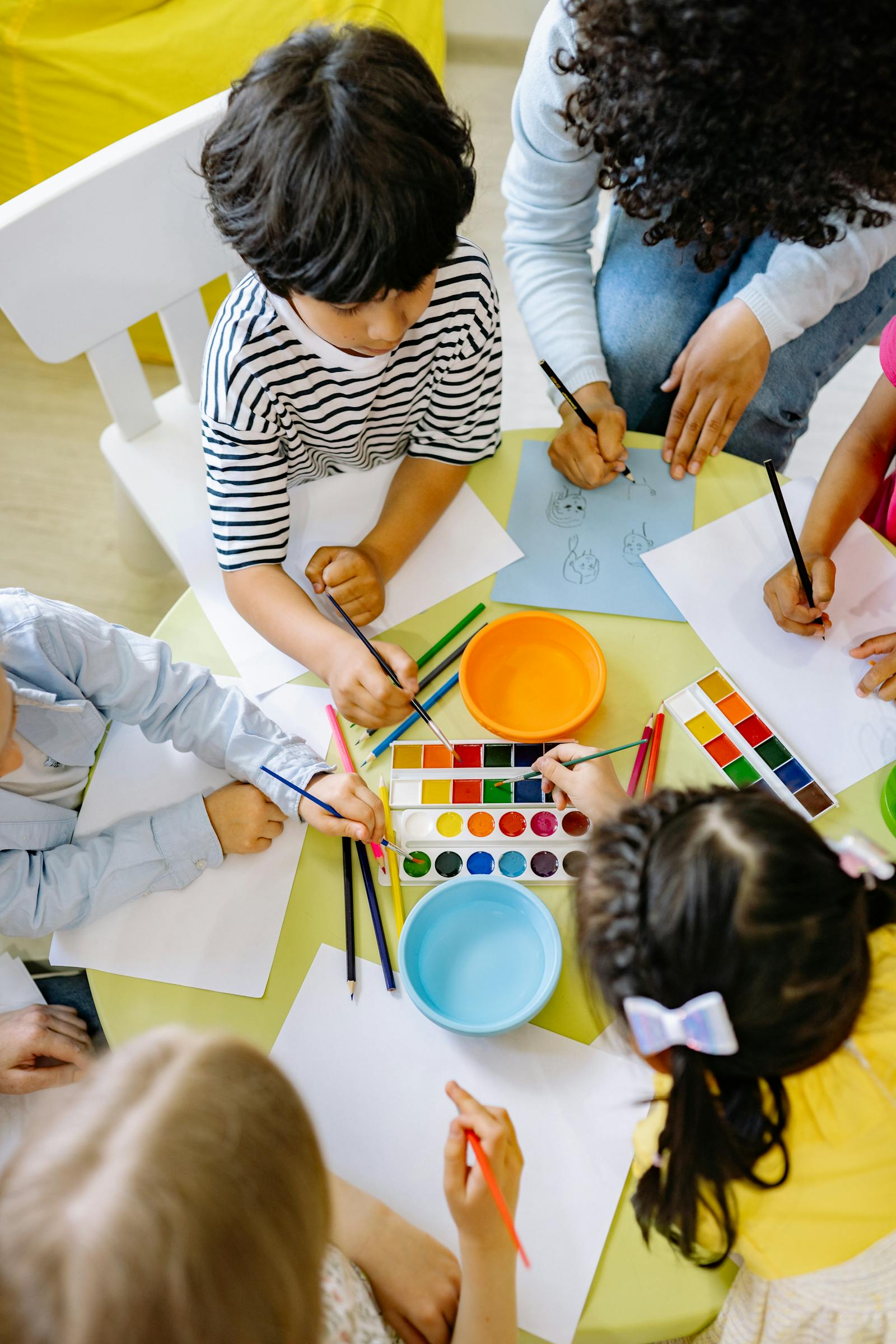Toddlers ages 1–2 years doing hands-on art at a Montessori preschool